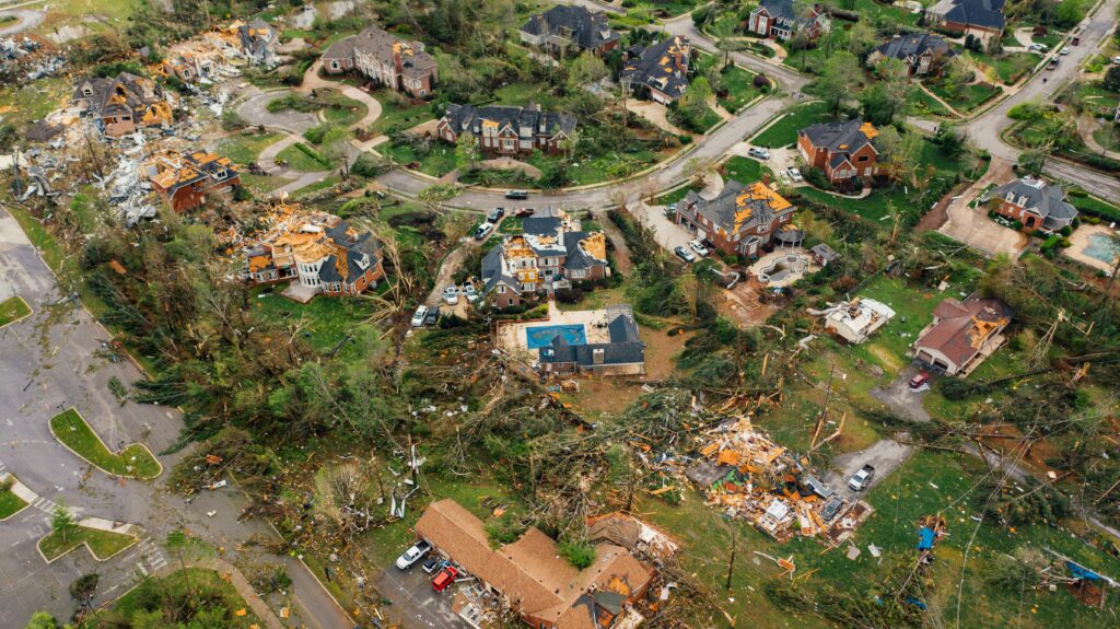 Aerial view of a residential neighborhood in Tampa Bay severely damaged by a hurricane, showing extensive storm debris, fallen trees, and damaged homes, highlighting the need for professional debris removal and property cleanup services