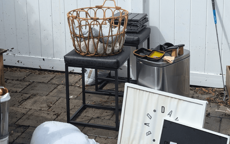 Backyard patio with unwanted items and furniture staged for a residential junk removal service in Tampa Bay by Site Masters.