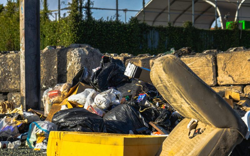 A pile of illegally dumped trash bags and junk on a gravel lot in Tampa awaiting professional debris removal services.