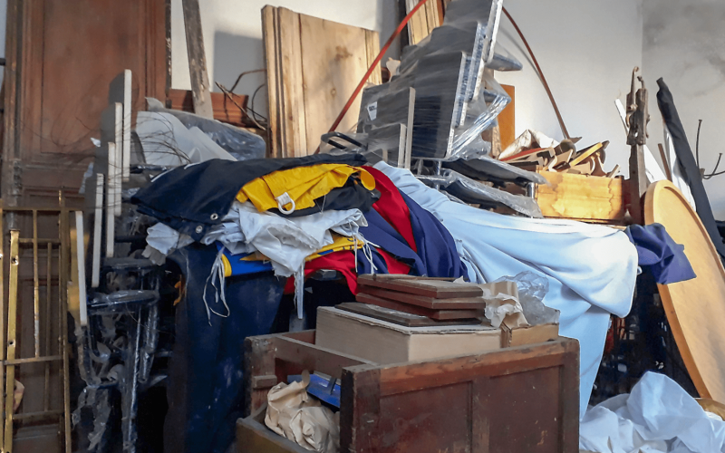 An overfilled storage unit in Tampa packed with old furniture, boxes, and junk before a professional cleanout service.