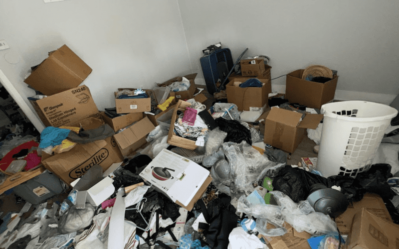 A cluttered room packed with junk before a professional hoarder cleanout and junk removal service in Tampa.